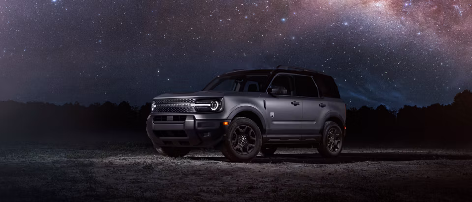 Gray 2025 Ford Bronco Sport parked outdoors beneath a star-filled night sky